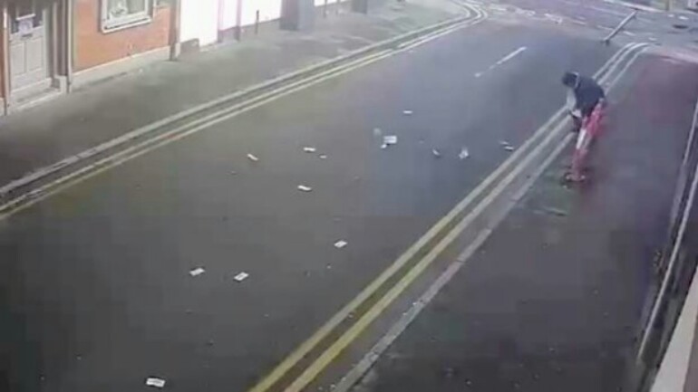 بالفيديو: لصين سيئي الحظ منهمكين بجمع النقود المسروقة بعد سقوطها وتطايرها في الشارع