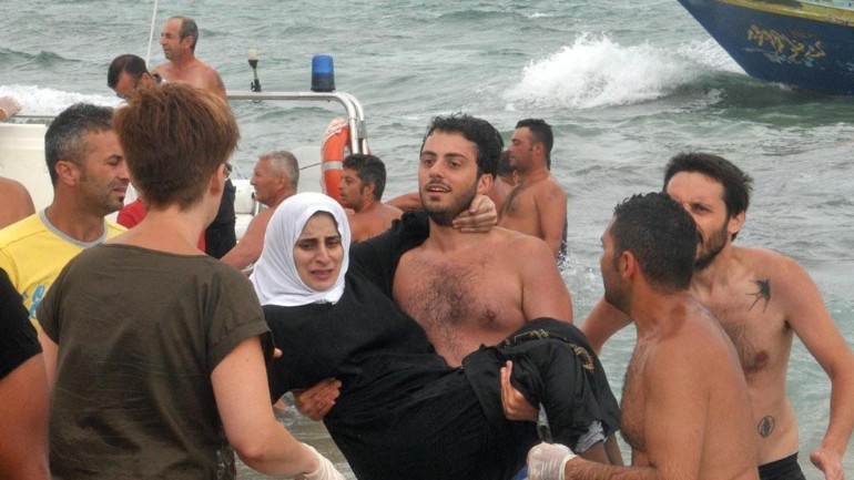المصطافين على شاطيء البحر في ايطاليا يساعدون خفر السواحل بعمليات إنقاذ اللاجئين