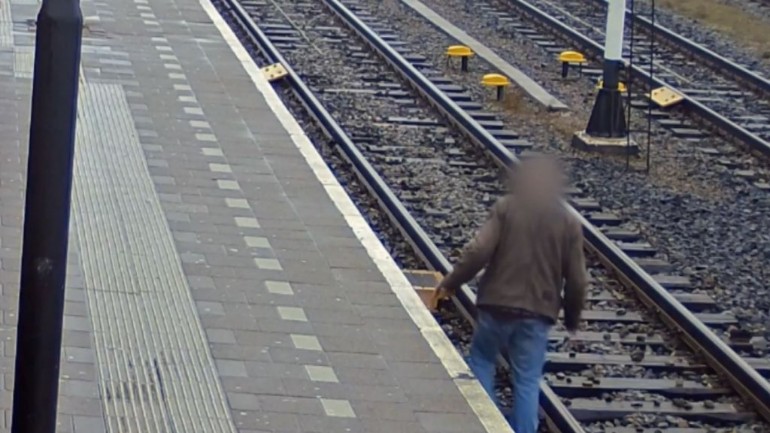 وضع خطير: يبحث الرجل عن أعقاب السجائر على السكة الحديدية في محطة رورموند