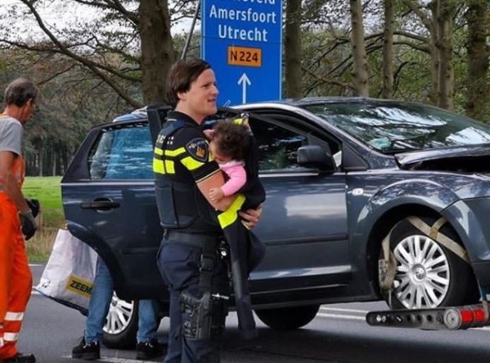 شرطية تعتني بطفلة بعد نقل والدتها إلى المشفى 
