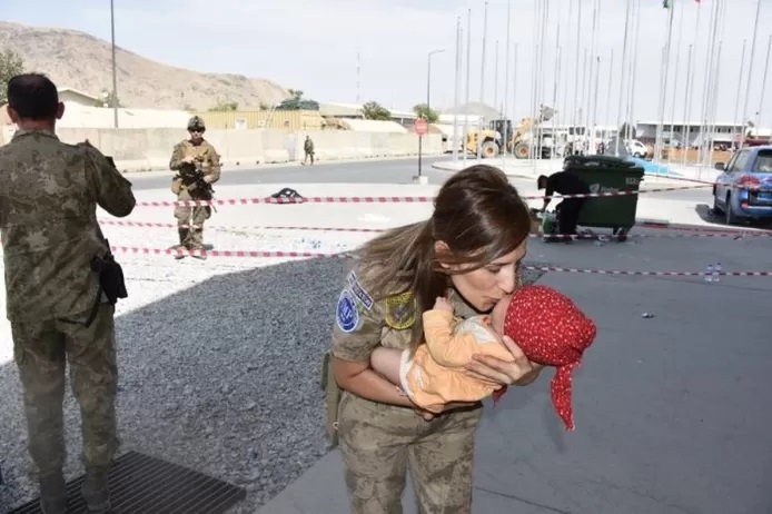 قتلى في مطار كابول • جنود أتراك يعتنون بطفل أفغاني منفصل عن والدته في المطار